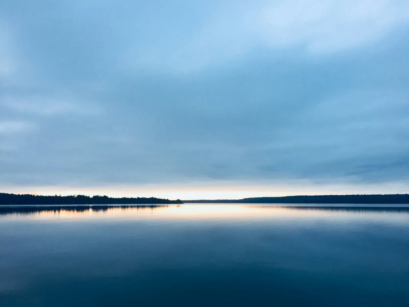 A wide, still lake at sunset A wide, still lake at sunset