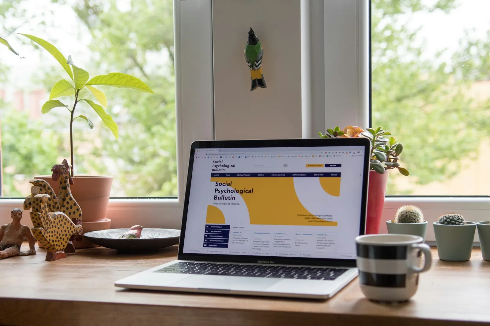 A home desk with a laptop and potted plants