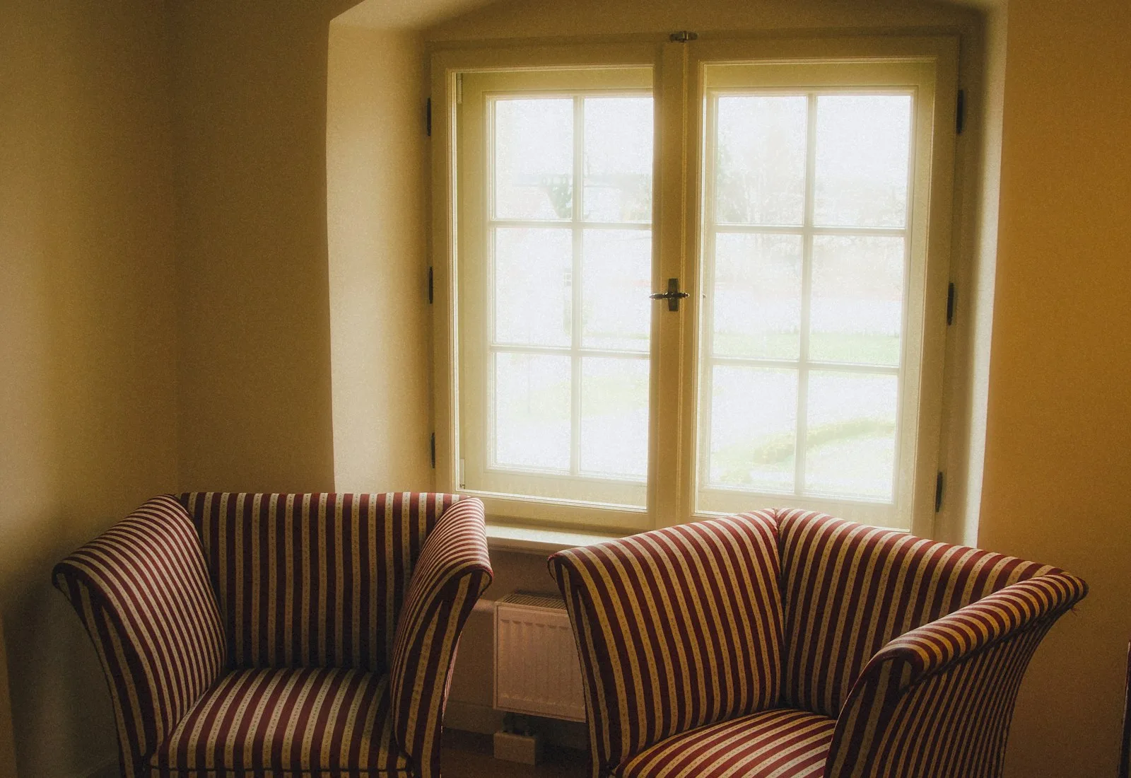 Two chairs by a window in a quiet room Two chairs by a window in a quiet room
