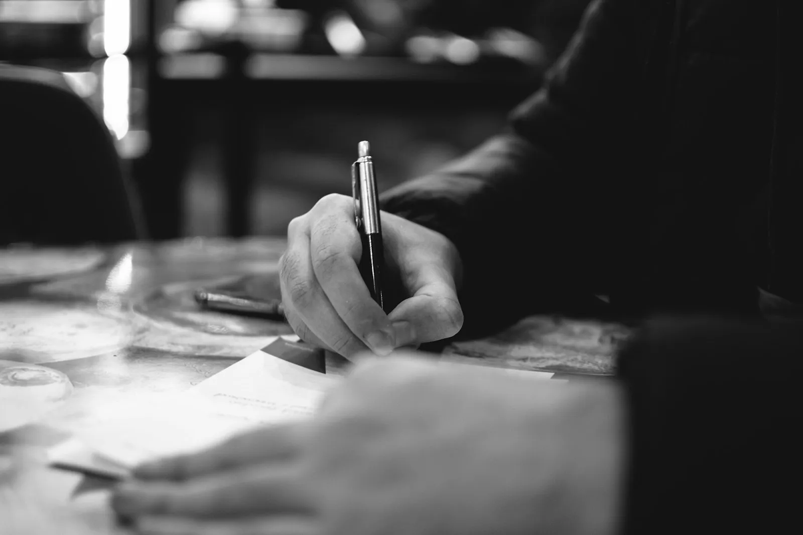 A hand writing a letter on plain paper A hand writing a letter on plain paper