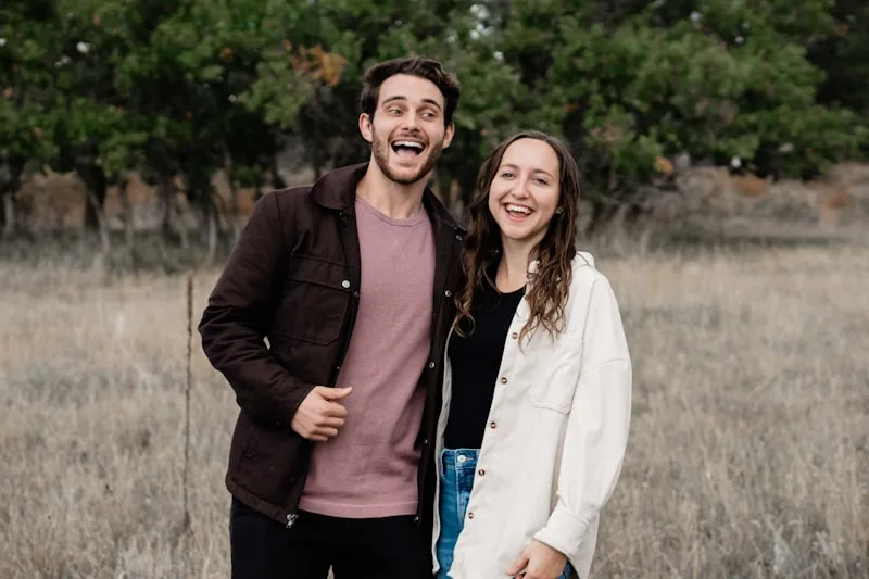 A couple standing together in an open field A couple standing together in an open field